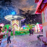 local tourists admire the artificial snow and lights displays at the bcc christmas village