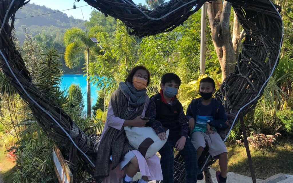 people sitting on a heart-shaped bench at Arca's Yard Baguio